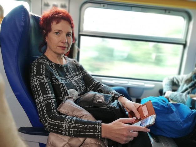Porträt einer Frau, die im Zug am Telefon sitzt