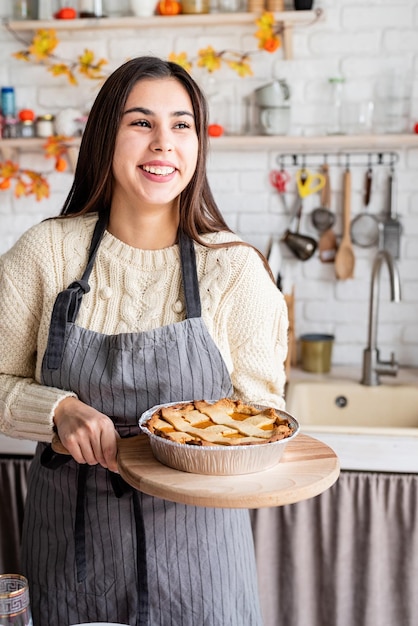 Porträt einer Frau, die Kürbiskuchen für Thanksgiving-Dinner in der heimischen Küche zubereitet