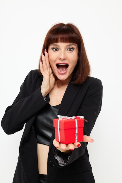 Porträt einer Frau, die mit rotem Geschenkbox-Überraschungshintergrund posiert