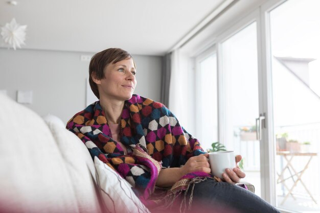 Porträt einer Frau, die sich zu Hause bei einer Tasse Kaffee entspannt