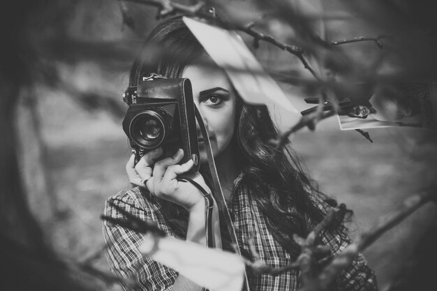 Porträt einer Frau, die von Zweigen fotografiert
