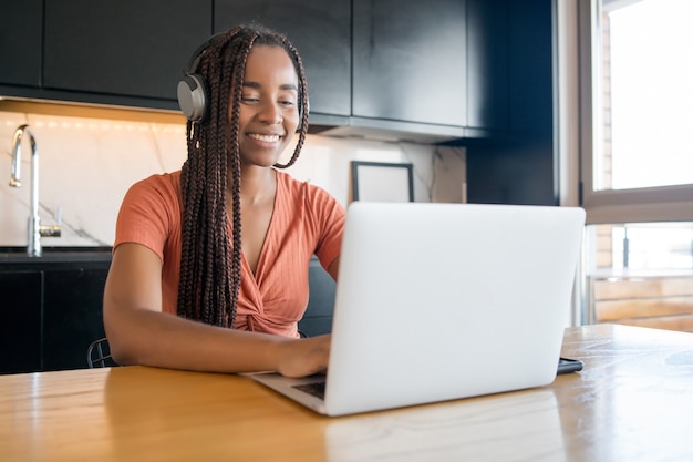 Porträt einer Frau, die zu Hause arbeitet und einen Videoanruf mit Laptop hat.