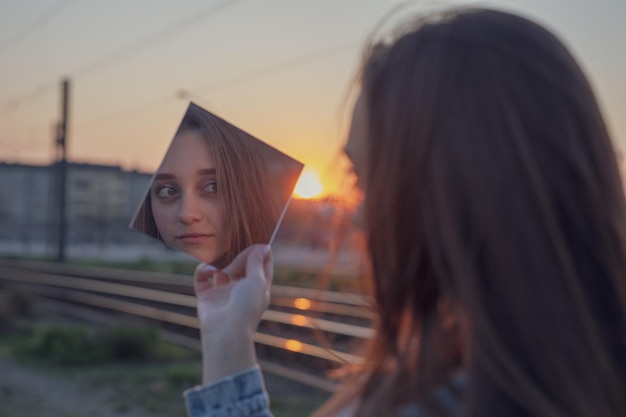 Porträt einer Frau gegen einen orangefarbenen Himmel bei Sonnenuntergang