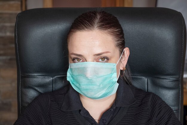 Porträt einer Frau in der medizinischen Gesichtsmaske bei der Arbeit