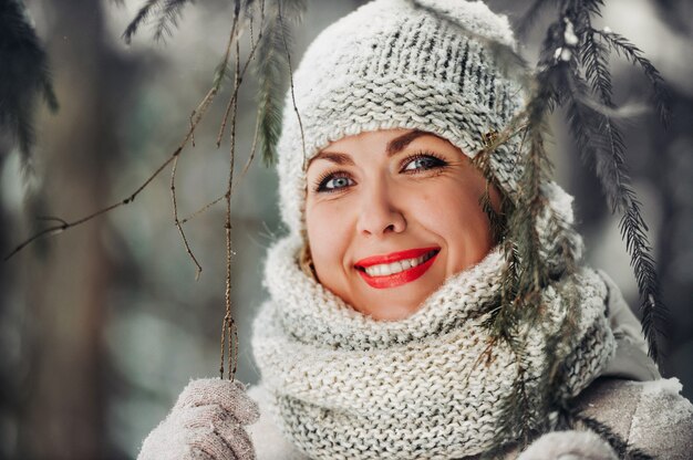 Porträt einer Frau in grauen Kleidern in einem Winterwald. Mädchen im schneebedeckten Neujahrswald.