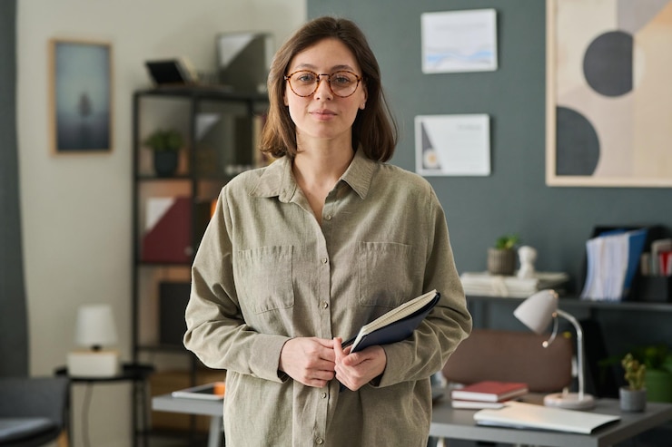 Foto porträt einer frau mit brille, die eine mappe im büro hält
