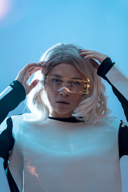 Porträt einer Frau mit der futuristischen Brille, blauem Hintergrund, Zukunft und Virtual-Reality-Konzept