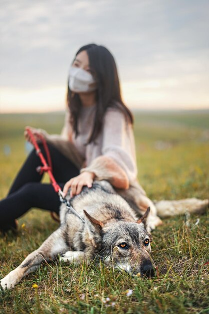Porträt einer Frau mit einem Hund auf dem Feld