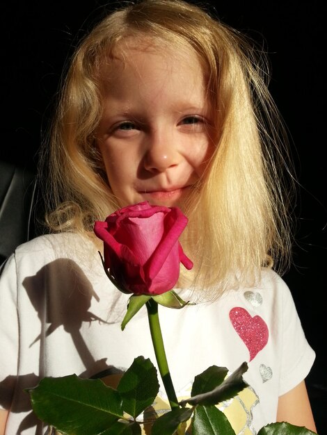 Foto porträt einer frau mit einer rosa blume