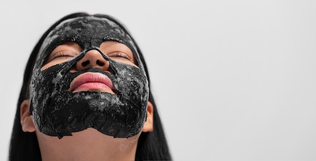 Porträt einer Frau mit Holzkohle-Gesichtsmaske