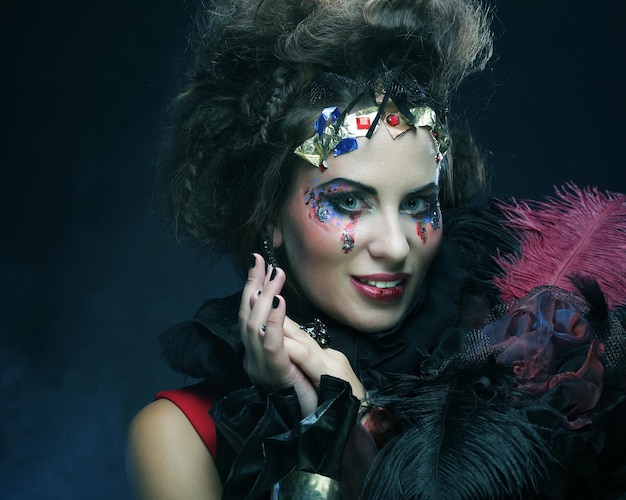 Porträt einer Frau mit künstlerischem Make-up in blauem Rauch-Party-Thema