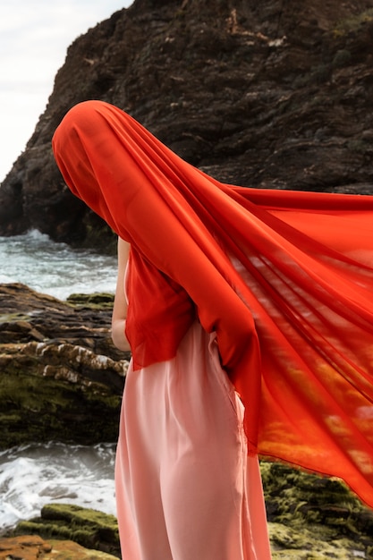 Porträt einer Frau mit verschleiertem Gesicht am Strand