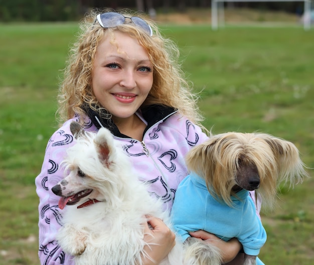 Foto porträt einer frau mit zwei hunden auf händen