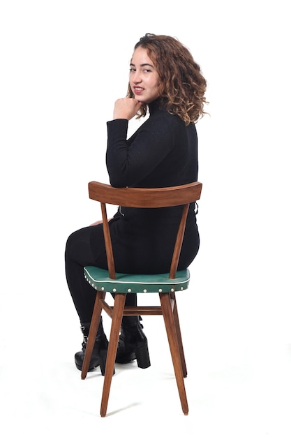 Porträt einer Frau sitzt auf einem Stuhl in weißem Hintergrund, Hand am Kinn