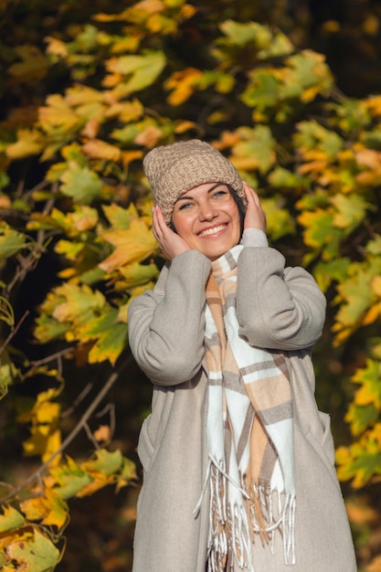 Porträt einer fröhlichen jungen Frau, die im Herbstpark genießt.