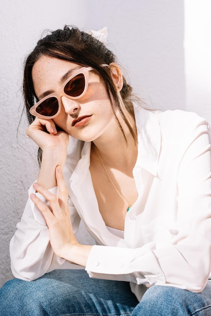 Porträt einer gelangweilten jungen Frau mit Sonnenbrille