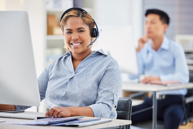 Porträt einer Geschäftsfrau und Call-Center-Beratung in einem Büro, das an einem Computer arbeitet. Lächelnde afrikanische Arbeitnehmerin und Web-Unterstützung einer Kontakt-Mitarbeiterin mit professionellem Telemarketing-Job