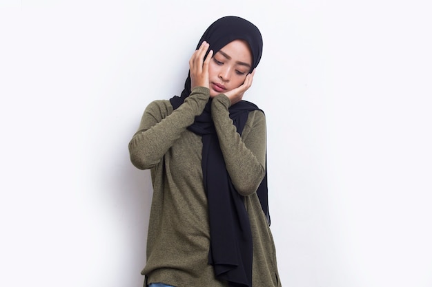 Porträt einer gestressten kranken asiatischen muslimischen Frau mit Kopfschmerzen auf weißem Hintergrund