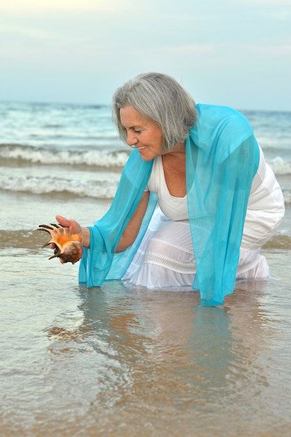 Porträt einer glücklichen älteren Frau am Strand