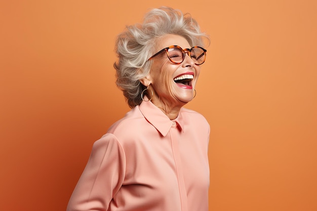 Porträt einer glücklichen älteren Frau, die vor der Kamera lächelt, isoliert über einem orangefarbenen Hintergrund