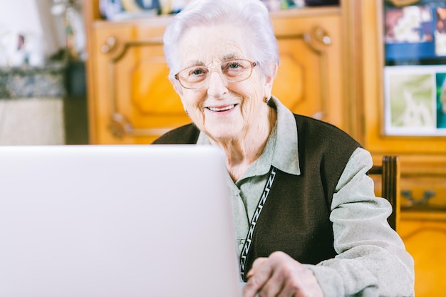 Porträt einer glücklichen älteren Frau mit Laptop