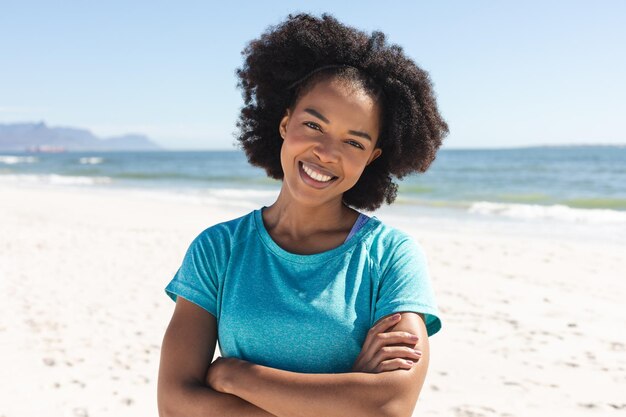 Porträt einer glücklichen afroamerikanischen Frau, die in die Kamera blickt und sonnig am Strand lächelt. Sommer, Lifestyle, Freizeit und Urlaub, unverändert.