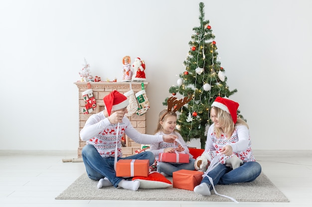 Porträt einer glücklichen Familie, die Geschenke zur Weihnachtszeit öffnet