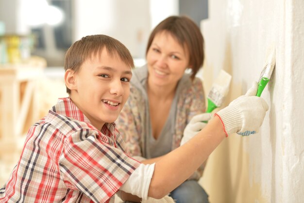 Porträt einer glücklichen Familie, die zu Hause repariert und Wand malt