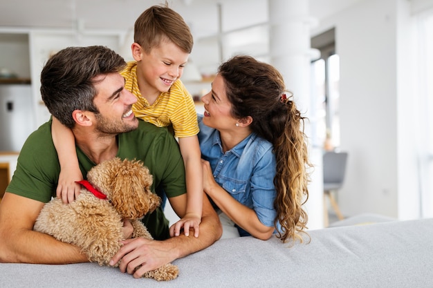 Porträt einer glücklichen Familie mit einem Hund, der sich zu Hause amüsiert. Konzept der glücklichen Familie, Liebe zu Tieren, Kindheit