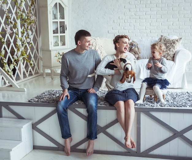 Porträt einer glücklichen Familie und ihres Haustiers in einem gemütlichen Wohnzimmer