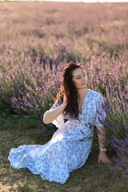 Porträt einer glücklichen Frau in einem blauen Kleid, die einen sonnigen Sommertag in einem Lavendelfeld genießt Frische Luft Lifestyle