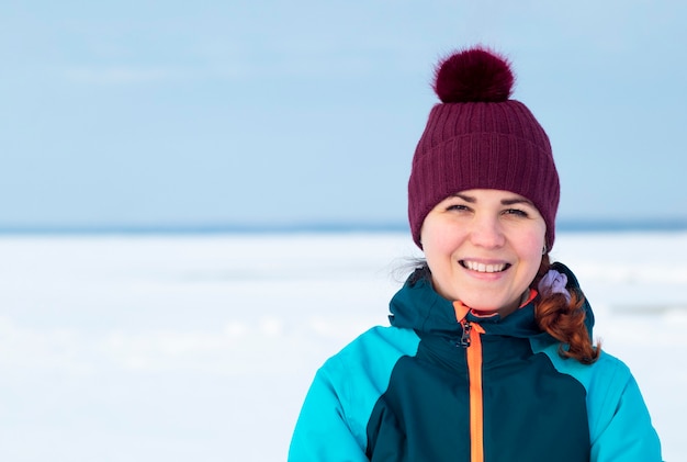 Porträt einer glücklichen fröhlichen Frau, die draußen in der warmen Winterkleidung steht