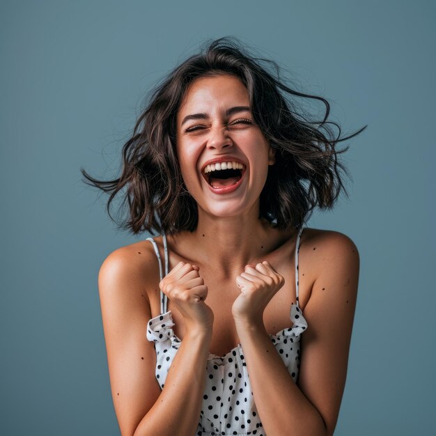 Porträt einer glücklichen jungen Frau, die isoliert über einem grauen Hintergrund lacht