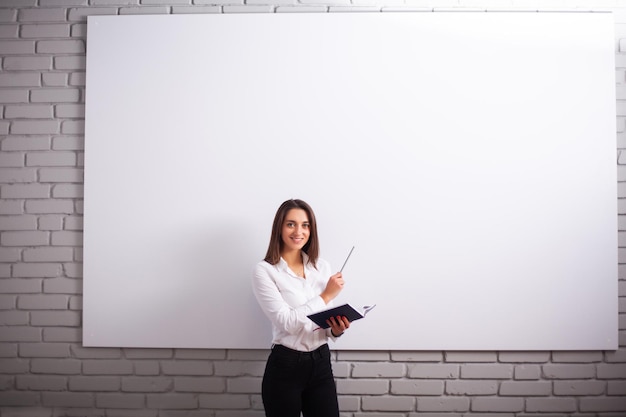 Porträt einer glücklichen jungen Geschäftsfrau in der Nähe einer weißen Wand.