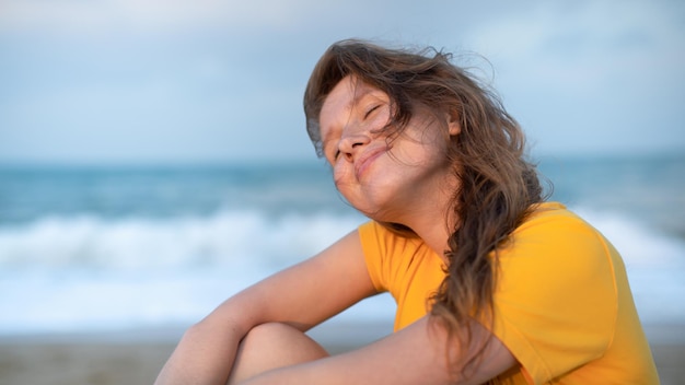 Porträt einer glücklichen jungen, unbeschwerten Frau, die den Sommerurlaub am Meer genießt und im Strandsand spaziert