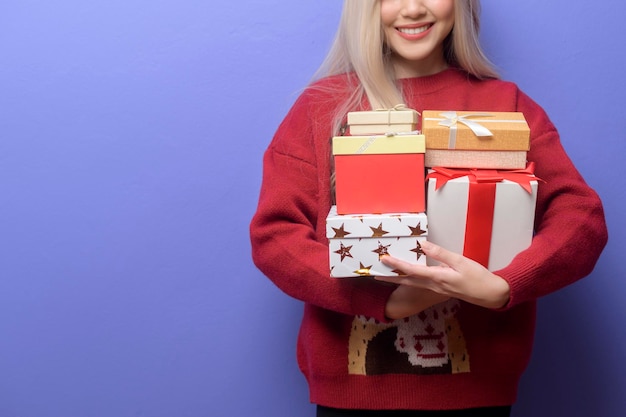 Porträt einer glücklichen kaukasischen jungen Frau mit Geschenkbox auf violettem Hintergrund