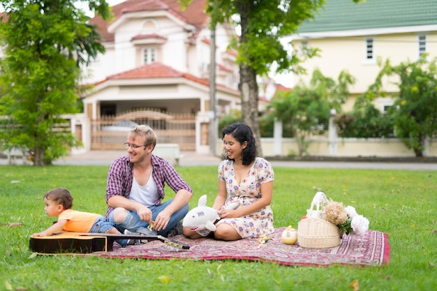 Porträt einer glücklichen multiethnischen Familie mit einem Kind, das sich im Freien zusammenschließt