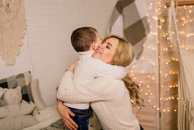 Porträt einer glücklichen Mutter und eines entzückenden Babys feiern Weihnachten. Neujahrsfeiertage.