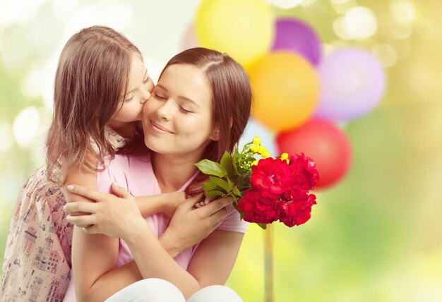 Porträt einer glücklichen Mutter und Tochter, die Blumen hält