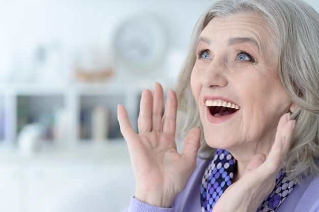 Porträt einer glücklichen, schönen älteren Frau, die zu Hause posiert