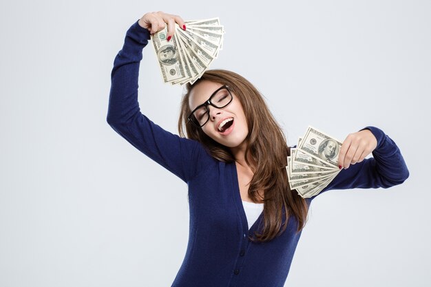 Porträt einer glücklichen schönen Frau mit geschlossenen Augen, die Geld auf einem weißen Hintergrund hält