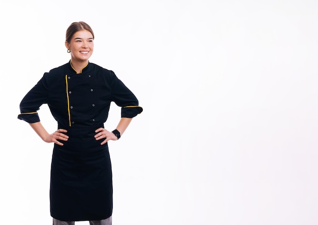 Porträt einer glücklichen, selbstbewussten jungen Kochfrau, die über weißem Hintergrund steht und wegschaut