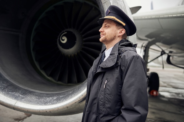 Porträt einer glücklichen, selbstbewussten kaukasischen Flugzeugbesatzung in der Nähe des Flugzeugs