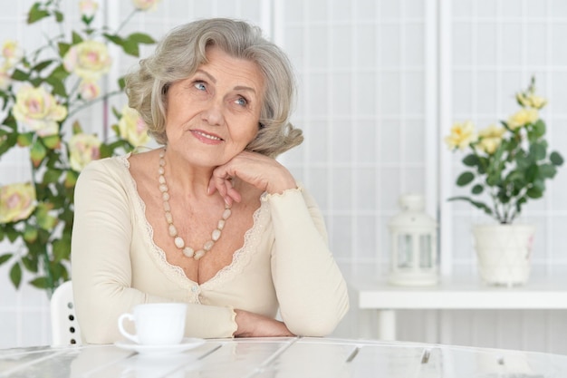 Porträt einer glücklichen Seniorin, die Tee trinkt