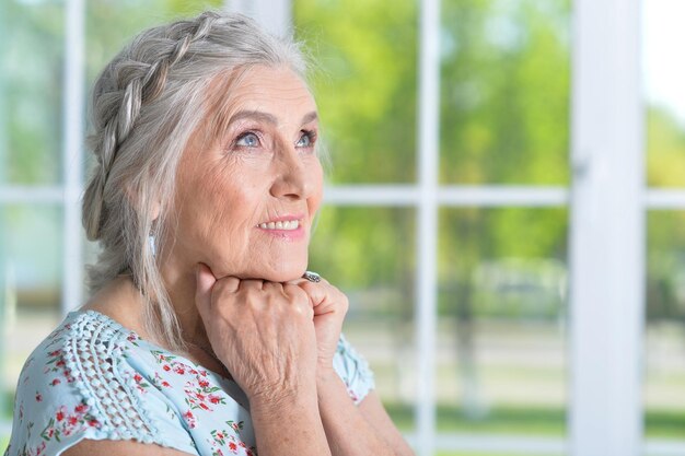 Porträt einer glücklichen Seniorin, die zu Hause posiert