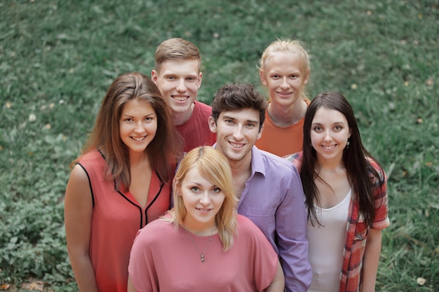 Foto porträt einer gruppe erfolgreicher junger menschen auf einem grünen rasen.