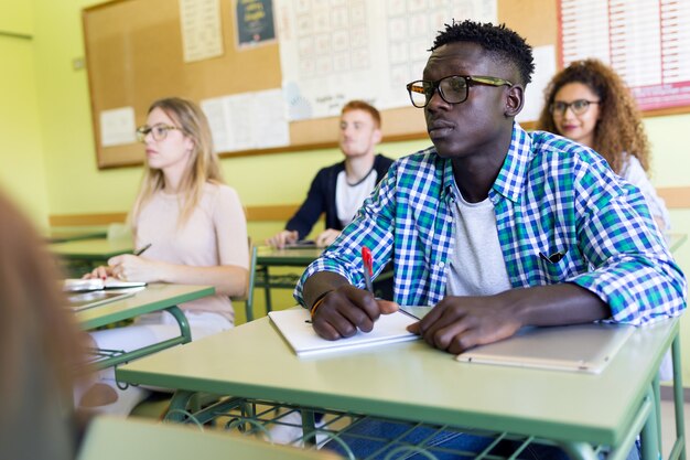 Porträt einer Gruppe von Freunden, die in einem Universitätsklassenzimmer studieren.