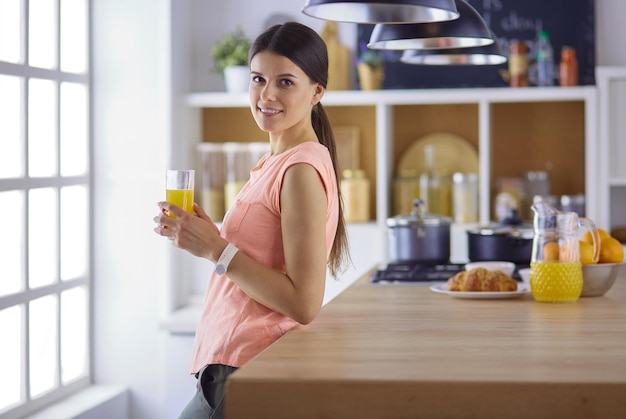 Porträt einer hübschen Frau, die ein Glas mit leckerem Saft hält