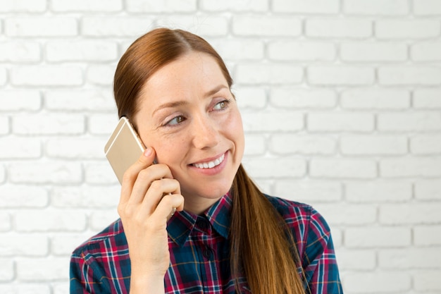 Porträt einer hübschen Frau, die einen Smartphone hält