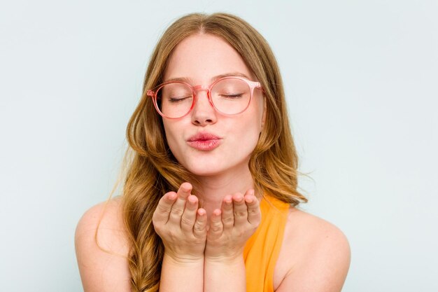 Porträt einer hübschen jungen Kaukasierin mit Brille isoliert auf blauem Hintergrund